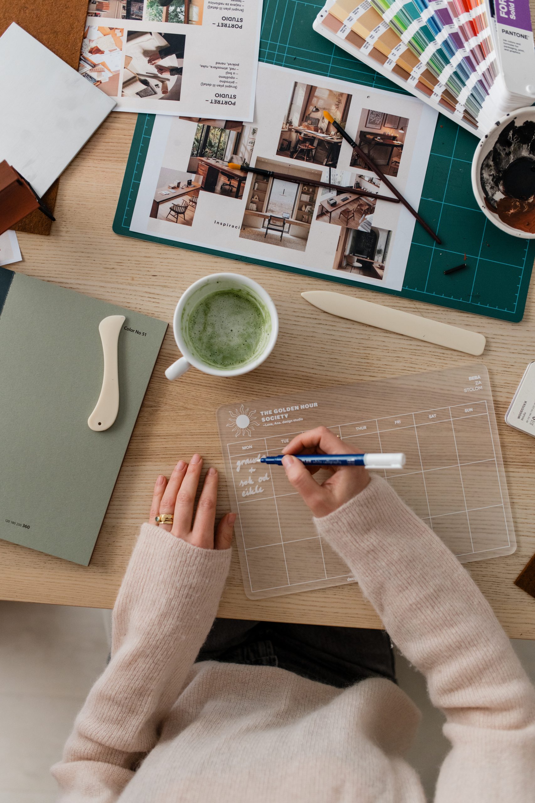 Desk with moodboards, paper samples and a Pantone guide